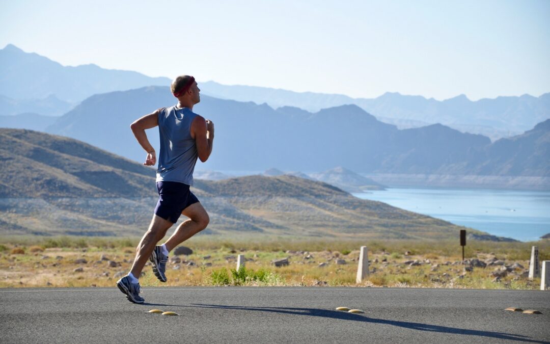 Man running on a road with mountains in the background